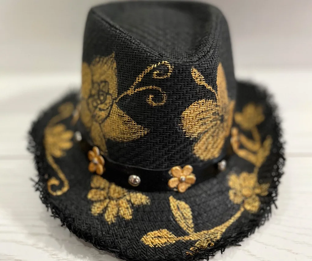 Sombrero negro de paja con flores doradas pintadas y borde deshilachado. - Gianluca Urraso